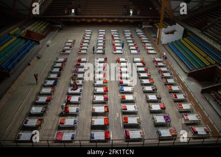 Srinagar, Inde. 27 avril 2021. Des rangées de lits sont placées à l'intérieur d'un stade sportif intérieur transformé en centre d'isolement COVID-19 à Srinagar. Le Jammu-et-Cachemire a signalé 3,164 cas positifs, le plus élevé depuis le déclenchement de la pandémie Covid-19 l'année dernière, faisant passer le nombre de cas actifs à 22,283, qui étaient autrement moins de 600 environ un mois auparavant. Une femme de 20 ans a été signalée parmi les vingt-cinq décès survenus dans J&K au cours des 24 dernières heures, portant le nombre de décès à 2,197. Crédit : SOPA Images Limited/Alamy Live News Banque D'Images