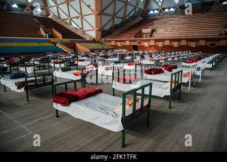 Srinagar, Inde. 27 avril 2021. Des lits sont placés pour installer un centre d'isolement Covid-19 à l'intérieur d'un stade sportif intérieur à Srinagar. Le Jammu-et-Cachemire a signalé 3,164 cas positifs, le plus élevé depuis le déclenchement de la pandémie Covid-19 l'année dernière, faisant passer le nombre de cas actifs à 22,283, qui étaient autrement moins de 600 environ un mois auparavant. Une femme de 20 ans a été signalée parmi les vingt-cinq décès survenus dans J&K au cours des 24 dernières heures, portant le nombre de décès à 2,197. Crédit : SOPA Images Limited/Alamy Live News Banque D'Images