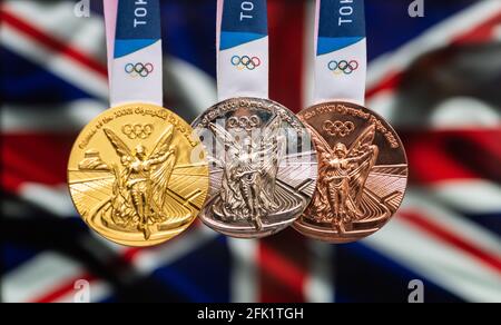 25 avril 2021 Tokyo, Japon. Médailles d'or, d'argent et de bronze des XXXII Jeux Olympiques d'été 2020 à Tokyo sur fond de drapeau de la Grande BRI Banque D'Images