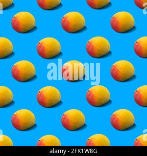 Motif d'arrière-plan coloré et de l'heure d'été illustration de fruits de mangue frais jaunes jetant une ombre dure sur une surface bleu vif. Nourriture estivale minimale c Banque D'Images