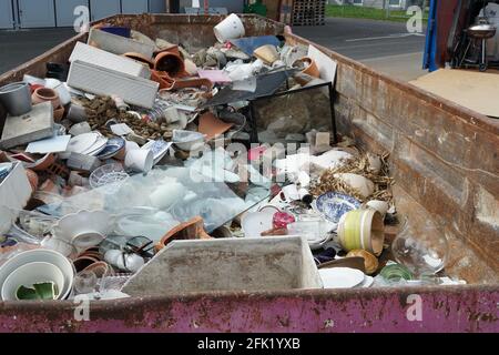 Déchets domestiques divers mélangés recueillis dans un conteneur dans un lieu d'élimination communautaire. Un service public gratuit pour éviter les littering. Banque D'Images