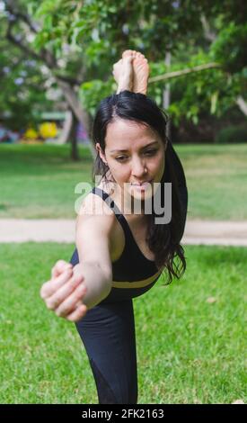 jeune femme pratiquant le yoga dans lord of the dance pose Banque D'Images