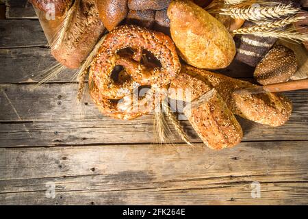Assortiment de délicieux pains fraîchement sortis du four, sur fond de bois rustique copie espace