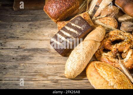 Assortiment de délicieux pains fraîchement sortis du four, sur fond de bois rustique copie espace