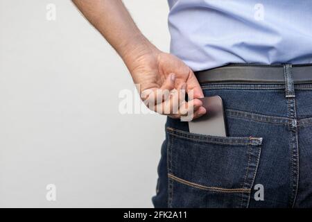 L'homme tire le téléphone portable de sa poche Banque D'Images