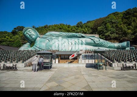 Temple bouddhiste Nazoin avec Bouddha couché. Ciel bleu et statue turquoise sur le côté. Bouddha le plus long du monde. Fukuoka, Japon Banque D'Images