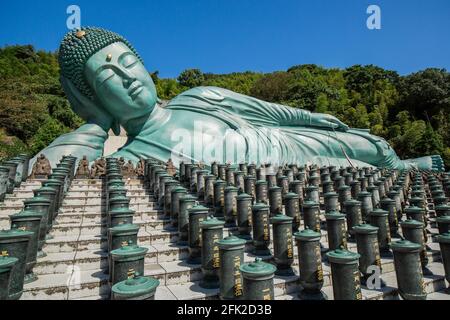 Temple bouddhiste Nazoin avec Bouddha couché. Ciel bleu et statue turquoise sur le côté. Bouddha le plus long du monde. Fukuoka, Japon Banque D'Images