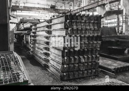 Anciennes poutres métalliques dans l'atelier de renfort. Métal emballé dans une entreprise industrielle, site de construction. Banque D'Images