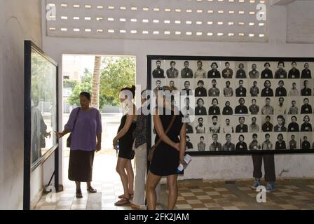 Un guide et des touristes voient des photos de prisonniers au Musée du génocide de Tuol Sleng, anciennement prison de sécurité 21, et un site de torture à Phnom Penh, au Cambodge. Banque D'Images