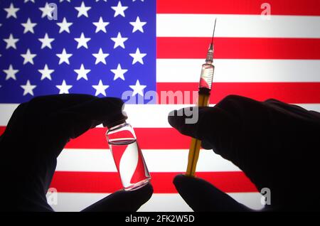 Dans cette illustration, une silhouette de mains en gants médicaux tient une seringue médicale et un flacon devant le drapeau américain. Banque D'Images