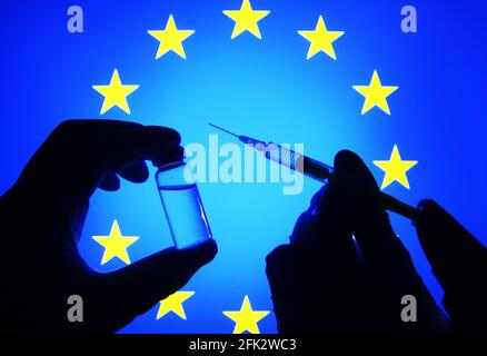 Ukraine. 27 avril 2021. Dans cette illustration, une silhouette de mains en gants médicaux tient une seringue médicale et un flacon devant le drapeau de l'UE. (Photo de Pavlo Gonchar/SOPA Images/Sipa USA) crédit: SIPA USA/Alay Live News Banque D'Images