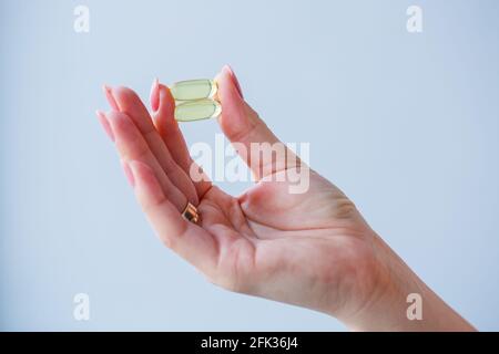 Main avec des pilules. La femme prend des médicaments pour améliorer l'immunité. Norme quotidienne de vitamines, préparations efficaces, pharmacie moderne pour la santé. Banque D'Images