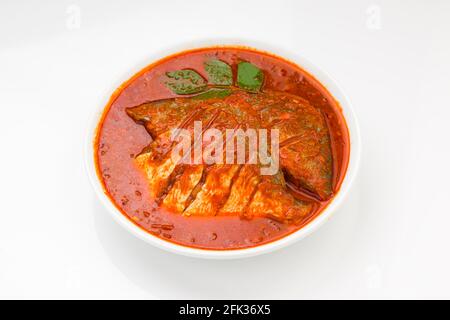 Cari masala blanc pomfret, fait dans le style indien du sud avec une épaisse sauce rouge et garni de piment vert, feuilles de curry et tamarin de malabar Banque D'Images