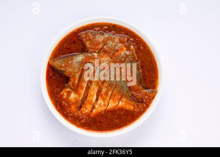 Cari masala blanc pomfret, fait dans le style indien du sud avec une épaisse sauce rouge et garni de piment vert, feuilles de curry et tamarin de malabar Banque D'Images