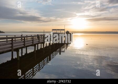 Herrsching, Allemagne - 22 février 2021 : coucher de soleil sur la jetée principale de Herrsching am Ammersee. Destination touristique populaire en haute-bavière. Banque D'Images