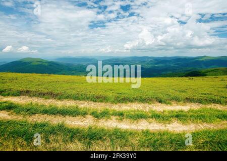 route de campagne à travers la prairie alpine de montagne de carpathian. beau paysage de la nature en été. paysage avec vue ouverte sur la crête lointaine et va Banque D'Images