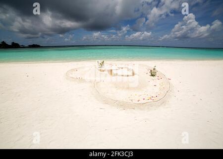 Coeur en sable blanc sur Paradise Island aux Maldives. Des nuages de mousson s'amassent sur l'île tropicale. Banque D'Images