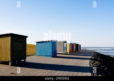 28 avril 2021, Schleswig-Holstein, Dagebüll: Des huttes en bois peintes en couleurs se tiennent au soleil sur la promenade du port. Photo: Frank Molter/dpa Banque D'Images