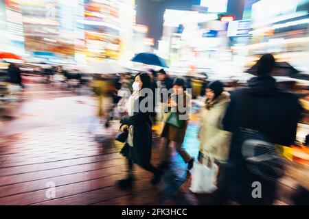 Tokyo, Japon - 13 décembre 2015 : AAbstract image d'une femme portant un masque facial au Shibuya Crossing à Tokyo, Japon. Banque D'Images