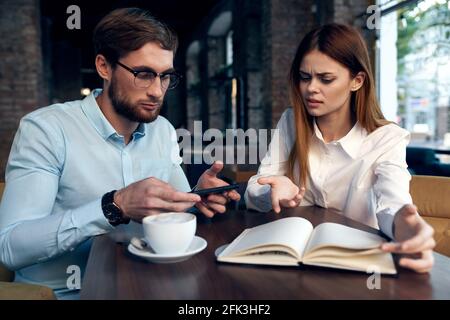 les collègues de travail dans un café s'assoient à la table du petit déjeuner communication Banque D'Images
