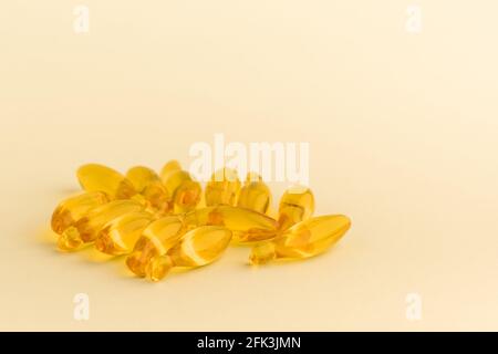 Capsules de supplément d'huile de poisson omega-3 isolées sur la surface jaune. Concept de soins de santé Banque D'Images