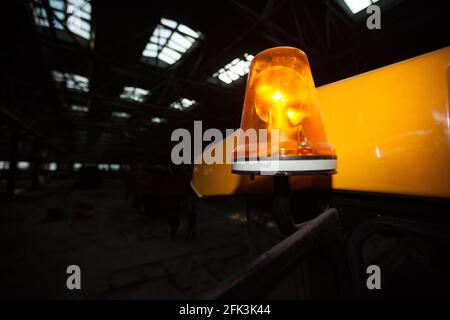 Témoin d'avertissement jaune sur la cabine du chariot. Atelier de construction automobile. Arrière-plan sombre. Banque D'Images