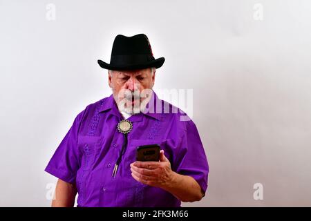 Homme âgé horrifié par ce qu'il voit sur son smartphone Banque D'Images