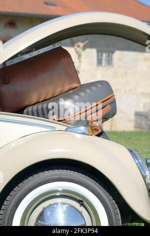 Vignette de voyage avec voiture classique et valises dans un style rétro environnement Banque D'Images