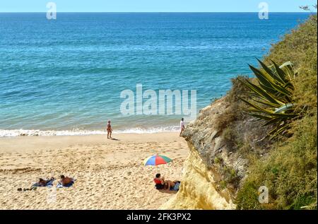 Les touristes profitant du beau temps sur Armaçao de Pera Beach sur la côte de l'Algarve Banque D'Images
