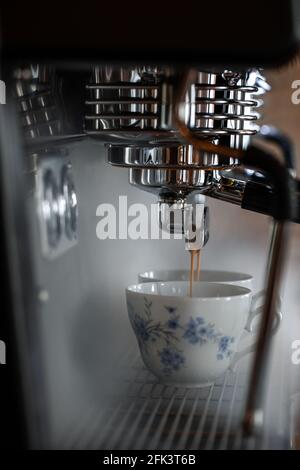 Processus de préparation de l'espresso avec la machine à café. De la vapeur et de magnifiques tasses de style campagnard Banque D'Images