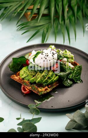 Sandwich à gaufres fraîches avec avocat et œuf poché Banque D'Images