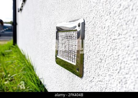 Admission d'air du manoir à la cheminée avec une chambre de combustion fermée, grille argentée sur la façade du bâtiment. Banque D'Images