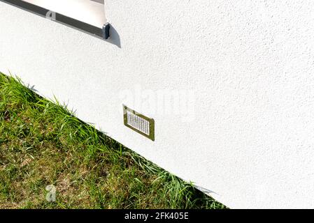 Admission d'air du manoir à la cheminée avec une chambre de combustion fermée, grille argentée sur la façade du bâtiment. Banque D'Images