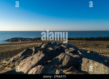 Lever du soleil à Claton sur la plage de Sea Beach, avec vue sur la mer du Nord en direction de Gunfleet Sands Wind Farm, Essex, Royaume-Uni. Avril 2021. Banque D'Images