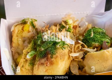 Big takoyaki, un gros plan de délicieux plats japonais frits de boulettes de poulpe dans une boîte de papier blanc au marché nocturne de Taipei, Taïwan. Banque D'Images