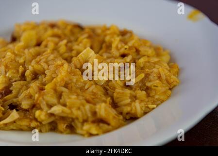 Risotto au poulet maison servi sur la plaque blanche. Riz italien servi en porcelaine. Plat typique de la cuisine brésilienne. Délicatesse culinaire. A fait maison Banque D'Images