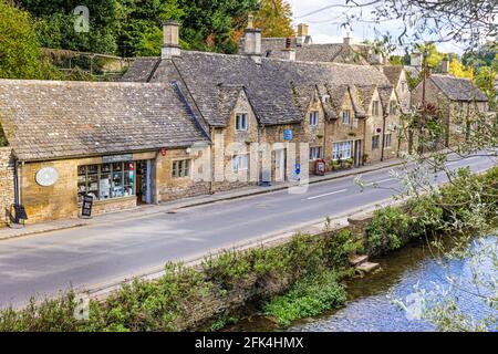 Cottages et boutiques à côté de la rivière Coln dans le village de Cotswold à Bibury, Gloucestershire, Royaume-Uni Banque D'Images