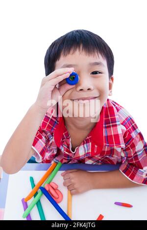 Petit garçon asiatique jouant et créant des jouets à partir de la pâte de jeu. Enfant souriant et montrer ses œuvres de l'argile, sur fond blanc. Renforcer l'imagination Banque D'Images