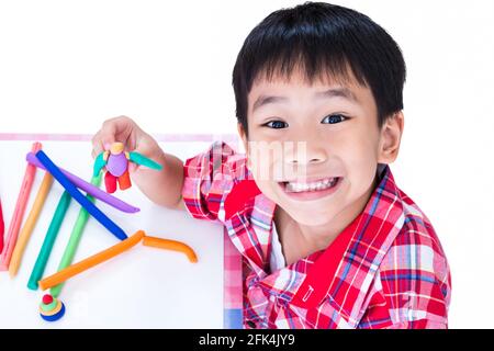 Petit garçon asiatique jouant et créant des jouets à partir de la pâte de jeu. Enfant souriant et montrer ses œuvres de l'argile, sur fond blanc. Renforcer l'imagination Banque D'Images