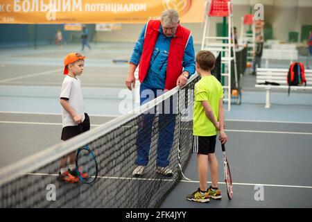 01 avril 2021. Biélorussie, la ville de Gomil. Concours pour enfants au grand tennis. Deux enfants avec raquettes de tennis et un juge sur le court de tennis. Banque D'Images