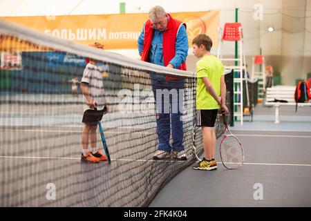 01 avril 2021. Biélorussie, la ville de Gomil. Concours pour enfants au grand tennis. Deux enfants avec raquettes de tennis et un juge sur le court de tennis. Banque D'Images