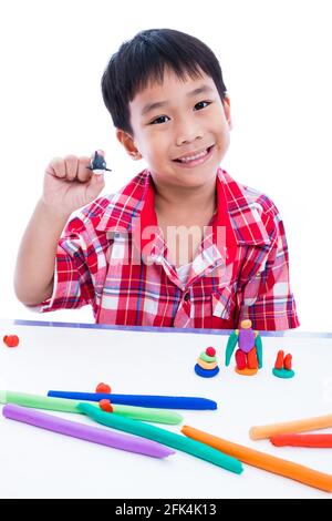 Petit garçon asiatique jouant et créant des jouets à partir de la pâte de jeu. Enfant souriant et montrer ses œuvres de l'argile, sur fond blanc. Renforcer l'imagination Banque D'Images