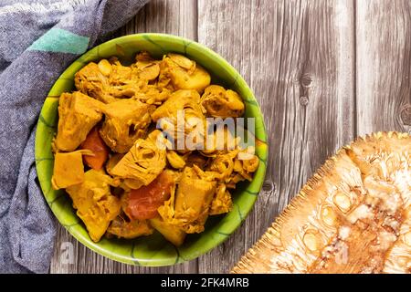 Plat de curry de fruits de jack dans un plat avec fruits de jack crus sur une table en bois Banque D'Images