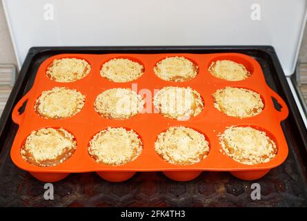 Des petits gâteaux faits maison fraîchement préparés sous forme de silicone rose à la maison cuisine Banque D'Images