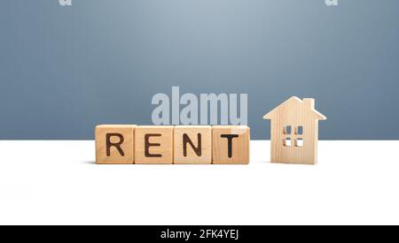 Maison en bois et le mot loyer. Rechercher une location de maison. Services de realtor. Location de logements et de biens immobiliers. Marché de location. Réservation de maisons Banque D'Images