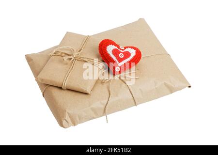 Deux colis de papier kraft attaché avec ficelle et petit coeur rouge fait main isolé sur fond blanc. Un cadeau pour la Saint-Valentin. Banque D'Images