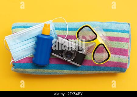 masque de protection et crème solaire sur une plage de vacances d'été serviette Banque D'Images