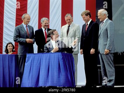 Le président des États-Unis George H.W. Bush signe une proclamation après avoir annoncé les plans de l'Initiative d'exploration spatiale (SEI) à l'occasion du 20e anniversaire de l'atterrissage sur la Lune d'Apollo 11 au Musée national de l'air et de l'espace à Washington, DC, le 20 juillet 1989. De gauche à droite : Marilyn Quayle (assis) ; Michael Collins, pilote du module de commande Apollo 11 ; Richard H. Truly, administrateur de la NASA ; président Bush ; Neil A. Armstrong, pilote du commandement Apollo 11 ; Dan Quayle, vice-président américain ; et Edwin (Buzz) Aldrin, pilote du module lunaire Apollo 11. Crédit : Robert Trippett/Pool via CNP | utilisation dans le monde entier Banque D'Images