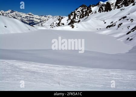 Les pistes de ski de traverser un lac gelé dans les montagnes de Suisse sur une belle journée ensoleillée Banque D'Images