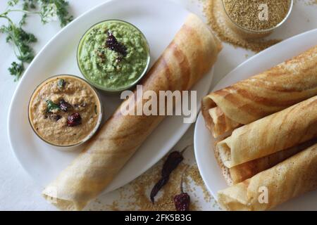 Crêpe croustillante à base de pâte fermentée de millet à queue de bœuf. Servi avec une variété de condiments à base de noix de coco. Prise de vue sur fond blanc. Banque D'Images